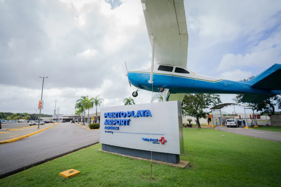 Acceso del aeropuerto de Puerto Plata (POP), con el letrero Puerto Plata Airport y una avioneta expuesta.