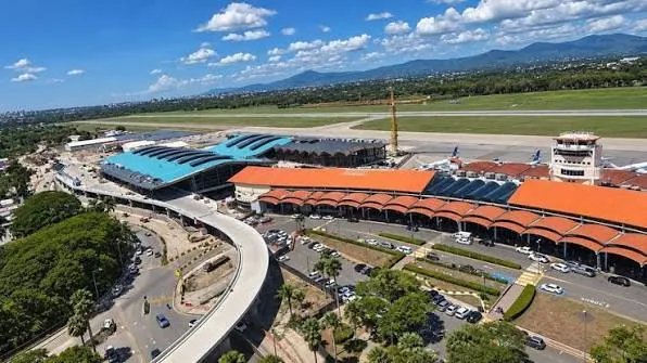Vista aérea de Cibao (STI), con cubiertas azules y terracota, torre de control y acceso elevado.